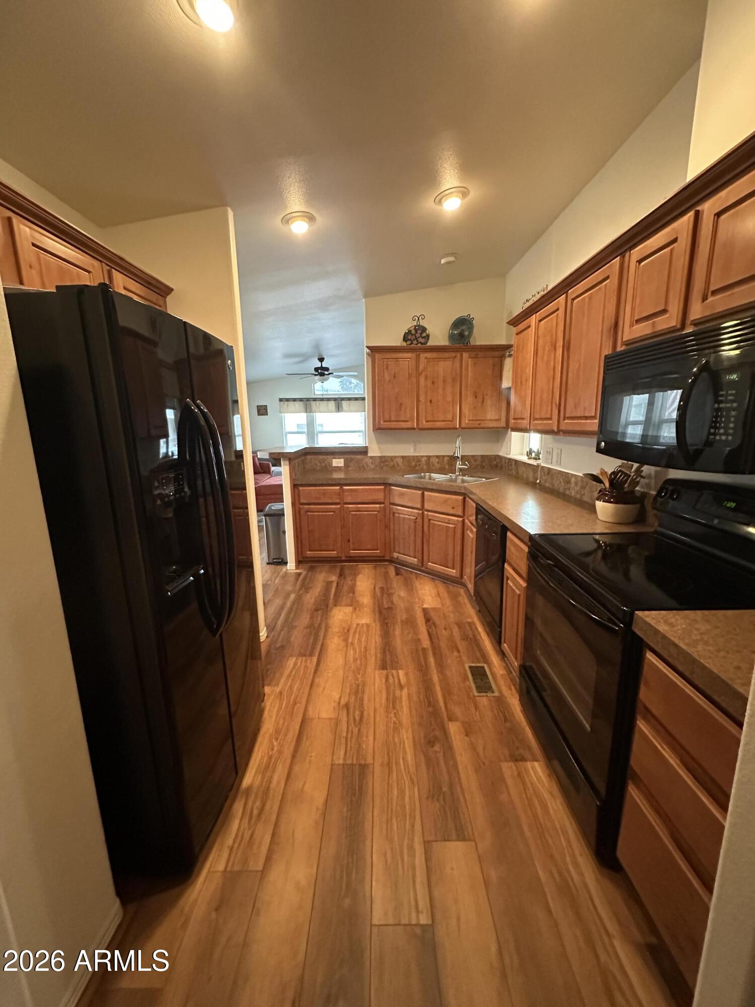 17200 West Bell Road, Unit 1658 Surprise, AZ 85374 - Photo 6 of 16 a kitchen with stainless steel appliances granite countertop a refrigerator a stove top oven and sink