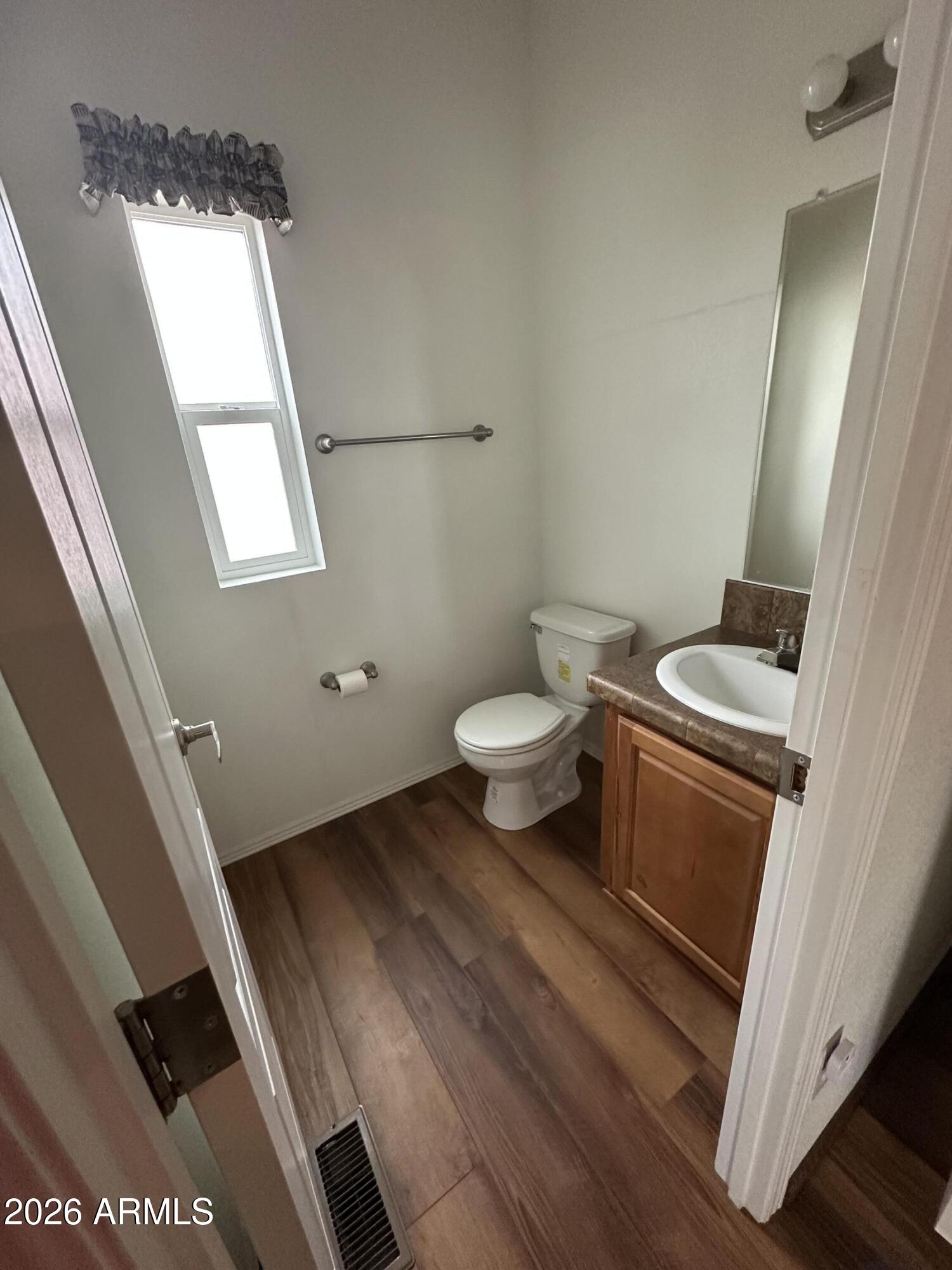 17200 West Bell Road, Unit 1658 Surprise, AZ 85374 - Photo 9 of 16 a bathroom with a toilet a sink and a mirror