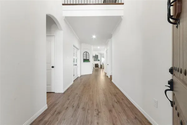 a view of a hallway with wooden floor and staircase
