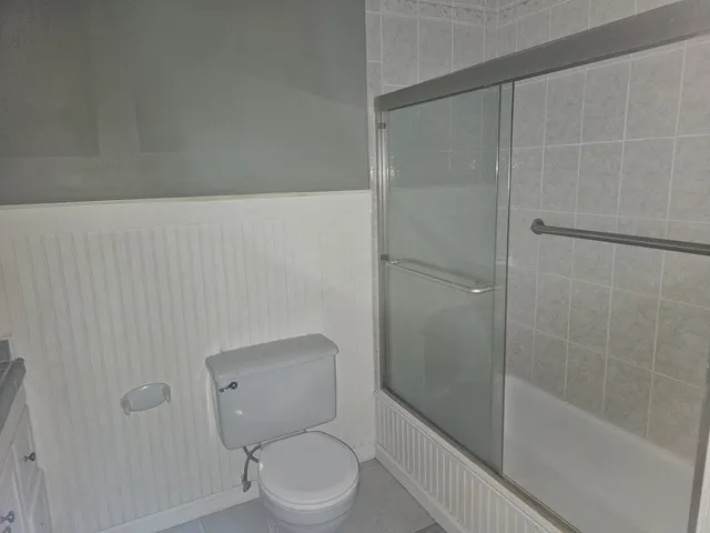 a white toilet sitting next to a bath tub