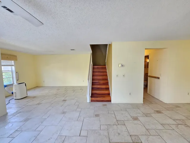 a view of an empty room with stairs and ventilation