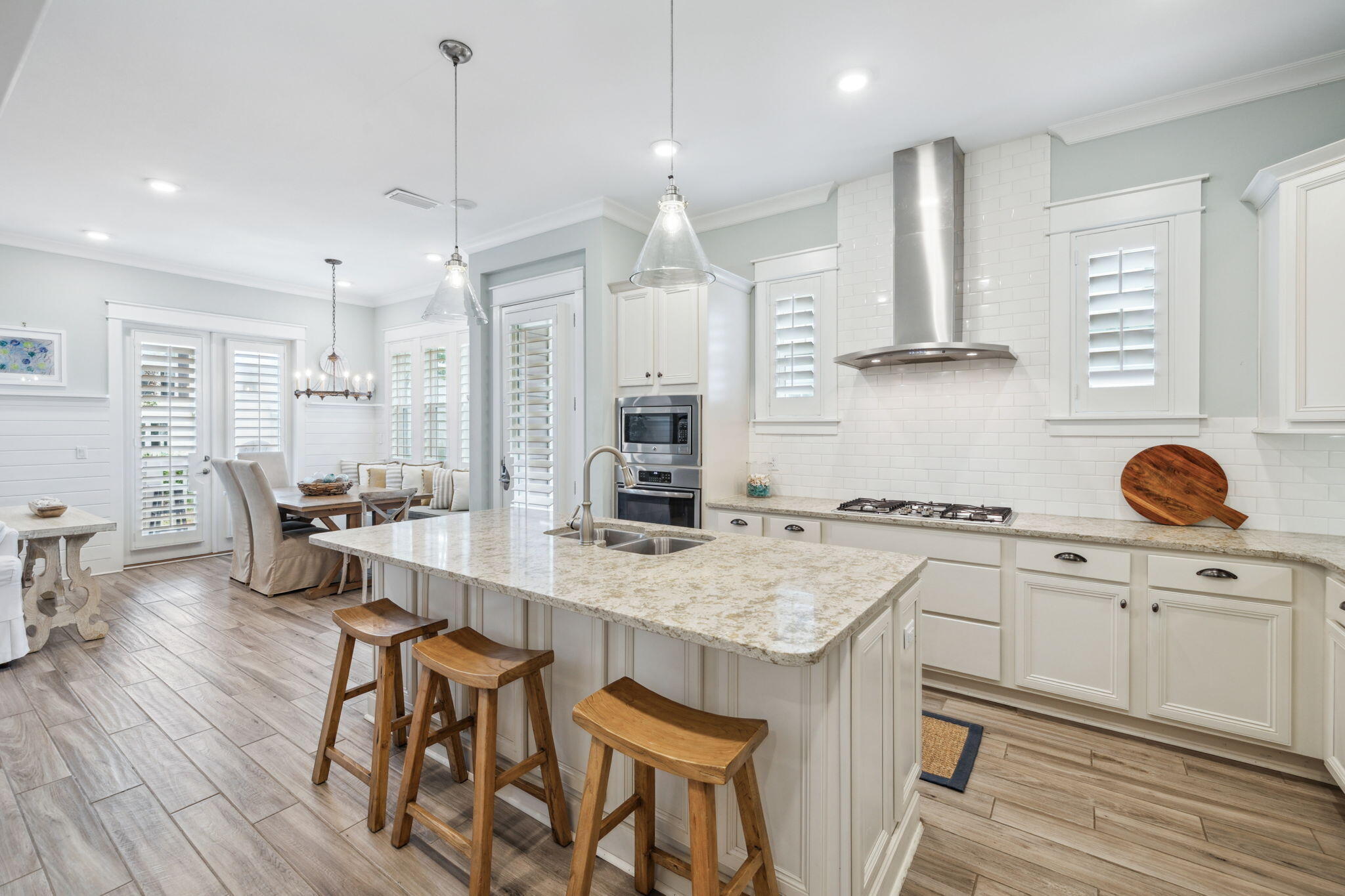 25 Pine Lands Loop East, Unit B Inlet Beach, FL 32461 - Photo 6 of 37 a kitchen with stainless steel appliances granite countertop a stove a sink dishwasher a refrigerator and white cabinets with wooden floor