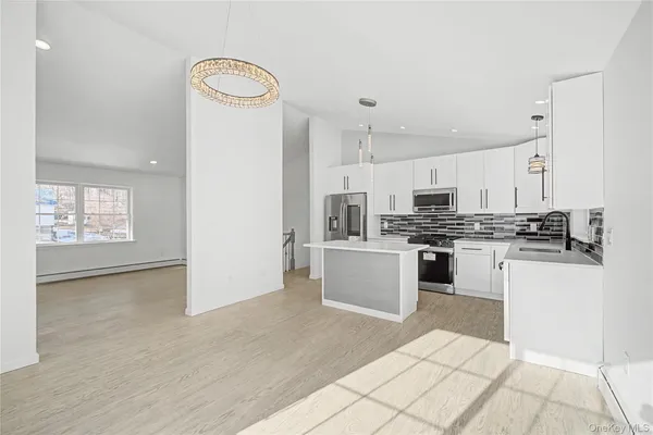 a kitchen with cabinets appliances a sink and a counter top space