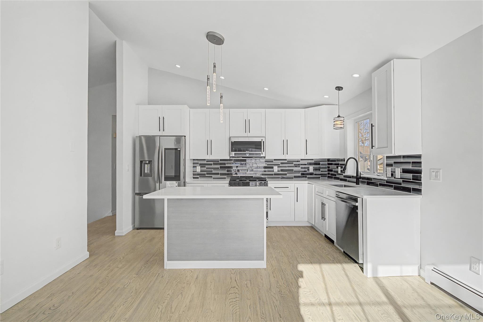 25 Clinton Street Middletown, NY 10940 - Photo 13 of 38 a kitchen with stainless steel appliances granite countertop a refrigerator a sink dishwasher a stove and white cabinets with wooden floor