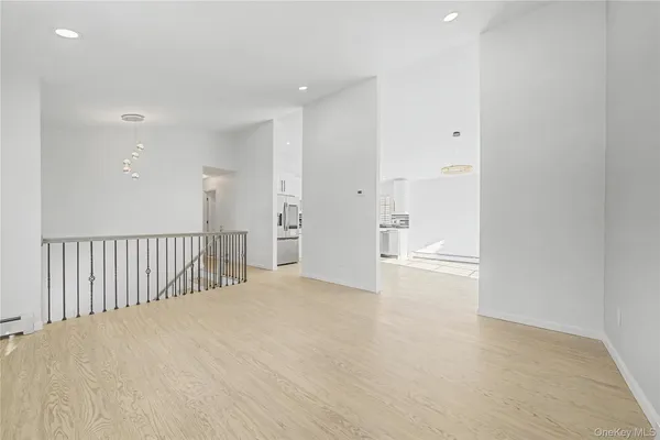 a kitchen with stainless steel appliances granite countertop a refrigerator a sink dishwasher a stove and white cabinets with wooden floor