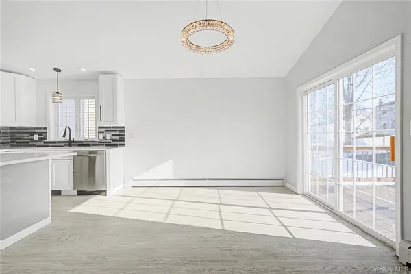 a kitchen with kitchen island white cabinets and stainless steel appliances