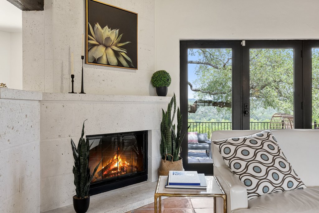 716 North Commons Ford Road Austin, TX 78733 - Photo 8 of 30 Corner fireplace with a light-toned stone surround