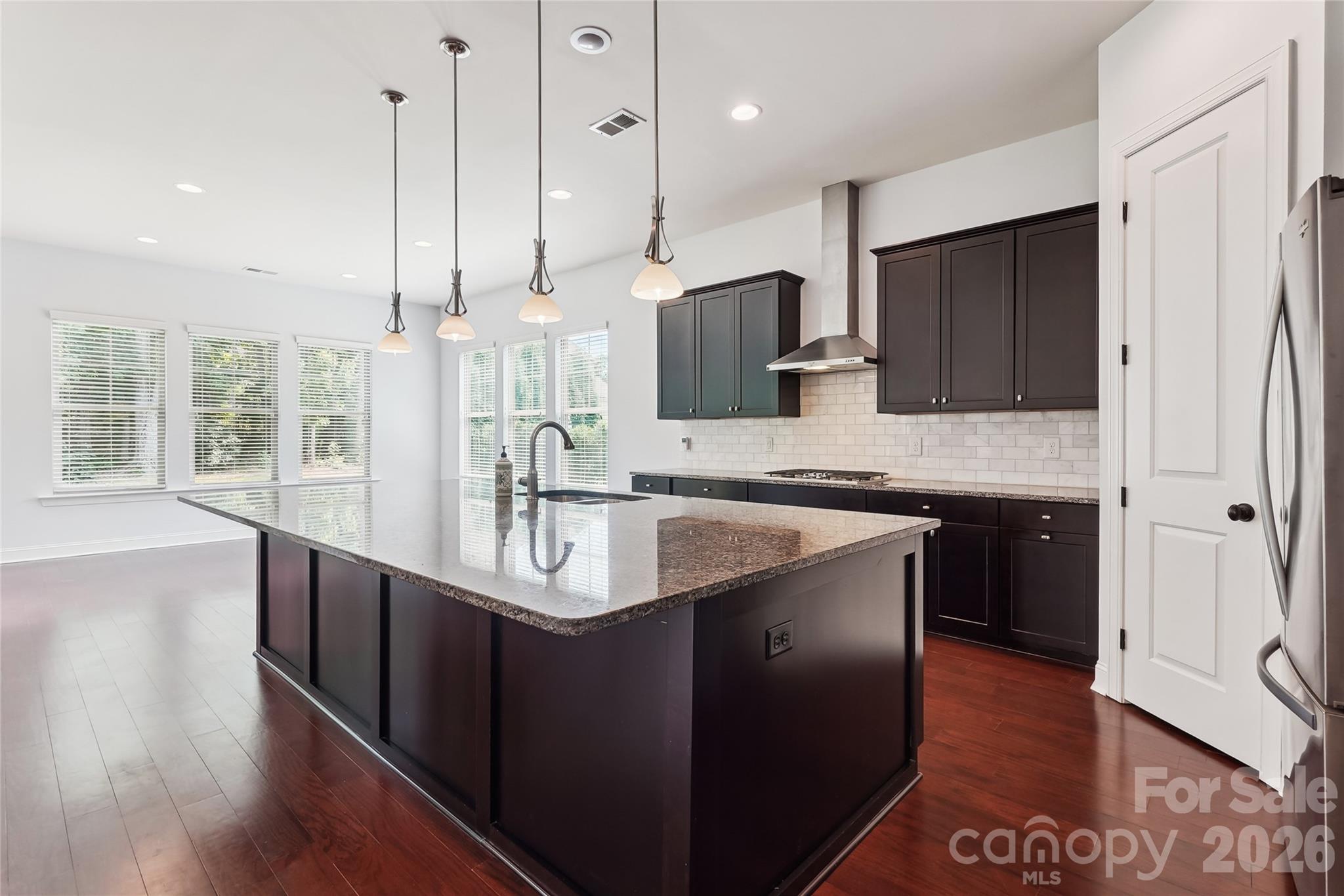 657 Chase Court Fort Mill, SC 29708 - Photo 16 of 39 a kitchen with stainless steel appliances granite countertop a sink a stove and a wooden floors