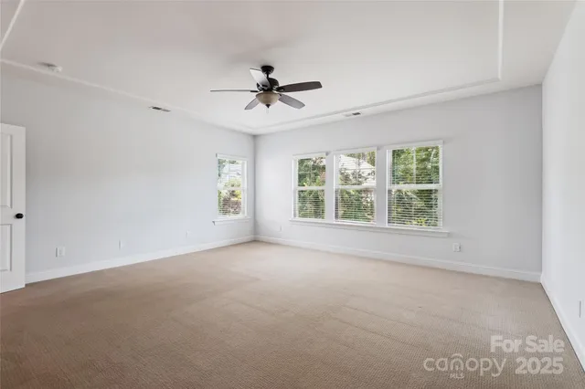a view of a big room with windows and chandelier fan