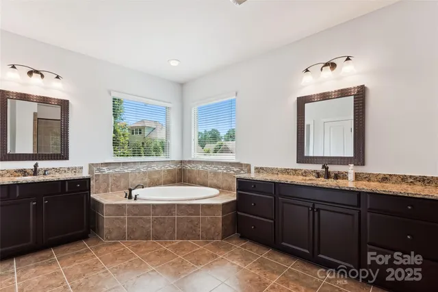 a bathroom with a tub a sink and mirror