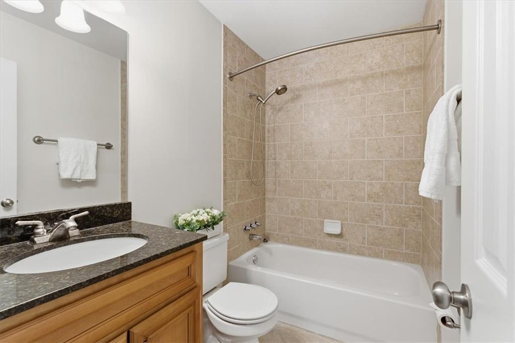 1468 Briarwood Road Northeast, Unit 303 Brookhaven, GA 30319 - Photo 20 of 32 a bathroom with a granite countertop bathtub shower sink vanity mirror and toilet