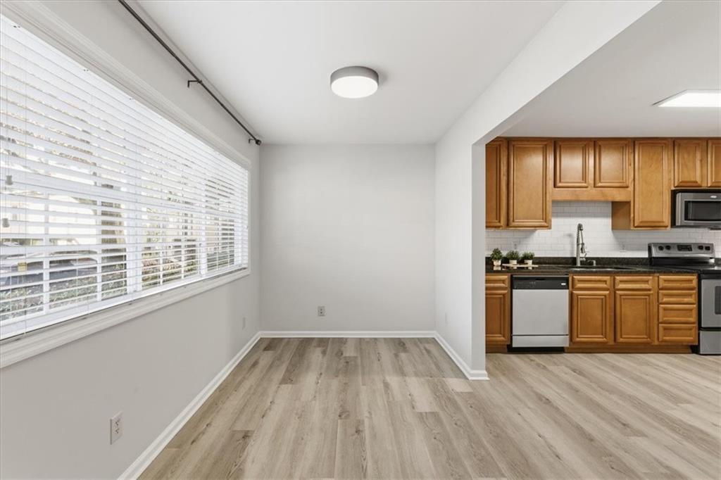 1468 Briarwood Road Northeast, Unit 303 Brookhaven, GA 30319 - Photo 6 of 32 a kitchen with a refrigerator and wooden cabinets