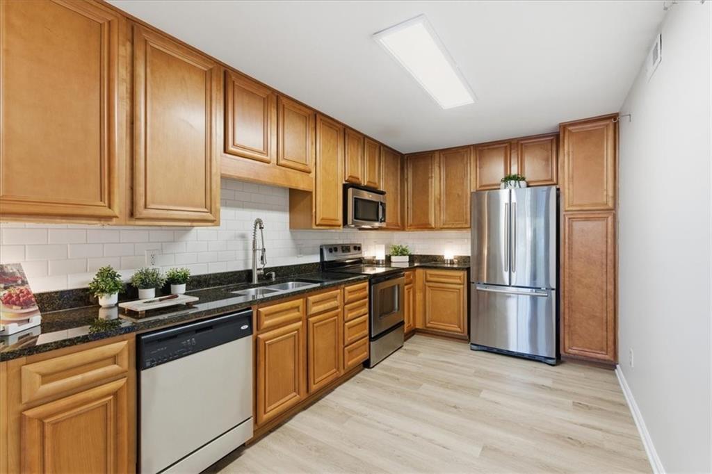 1468 Briarwood Road Northeast, Unit 303 Brookhaven, GA 30319 - Photo 7 of 32 a kitchen with stainless steel appliances granite countertop a refrigerator stove top oven and sink