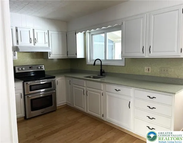a kitchen with granite countertop white cabinets and stainless steel appliances