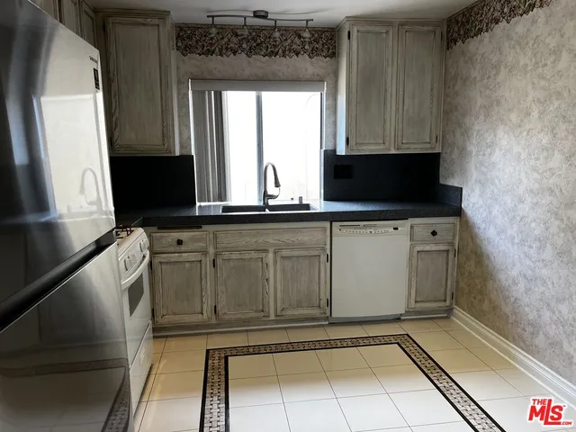a view of a kitchen with a sink a microwave and cabinets