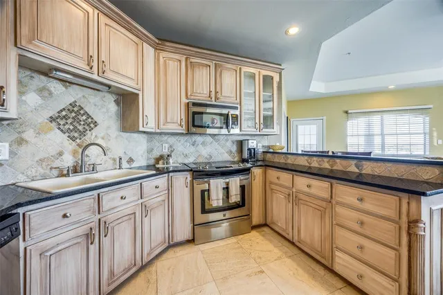 a kitchen with granite countertop cabinets stainless steel appliances a sink and window