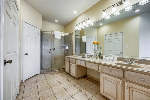 a bathroom with a double vanity sink mirror and a bathtub