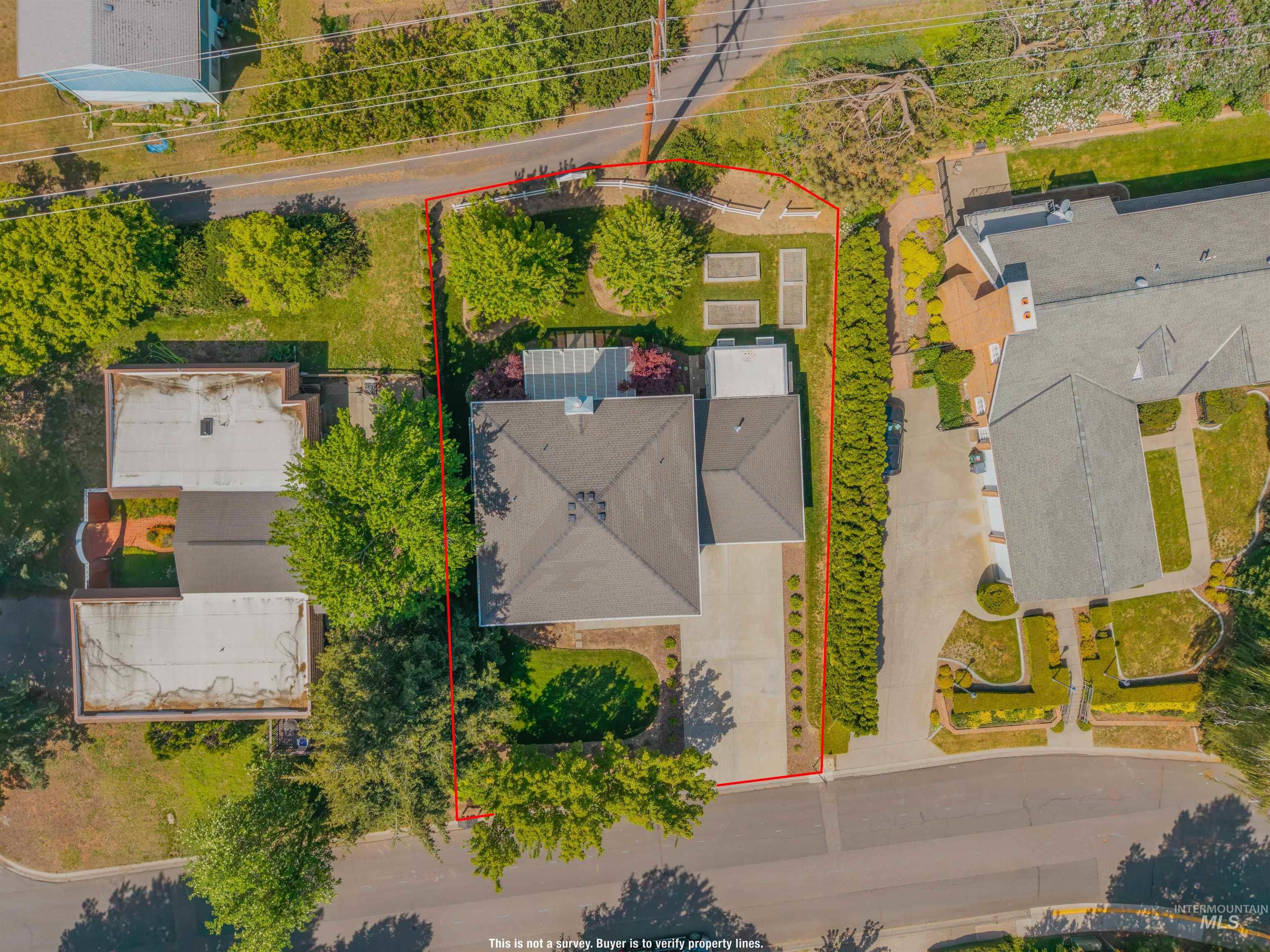 1617 Pine Cone Road Moscow, ID 83843 - Photo 41 of 44 Single-story home with a multi-gabled roof, featuring a paved driveway, mature landscaping, and a defined property boundary