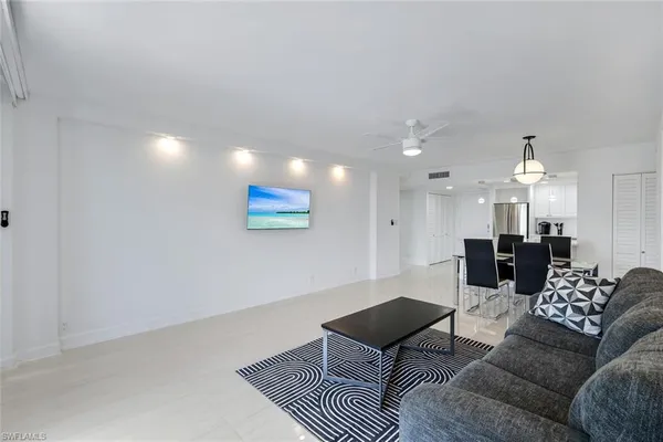 a living room with furniture and a dining table with kitchen view