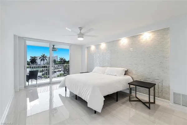 a large bed sitting in a room next to a window