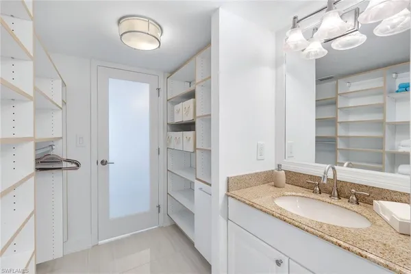 a bathroom with a granite countertop shower sink and a mirror