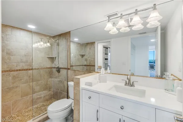 a bathroom with a sink a toilet and shower