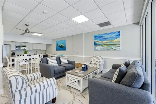 a living room with furniture kitchen view and a window