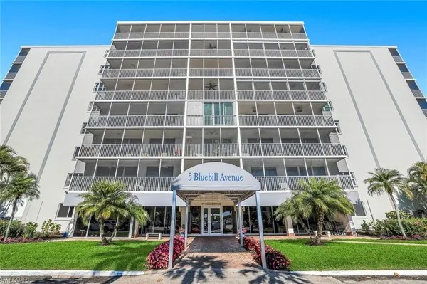 a front view of a building with a garden and plants