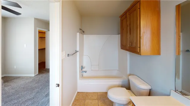 a white toilet sitting next to a bath tub