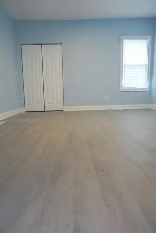 an empty room with windows and closet area