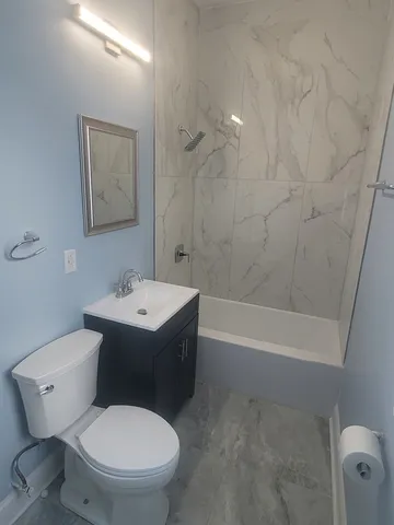 a white toilet sitting next to a bath tub