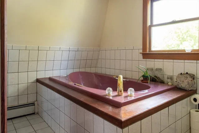 a bath tub sitting in a bathroom next to a window