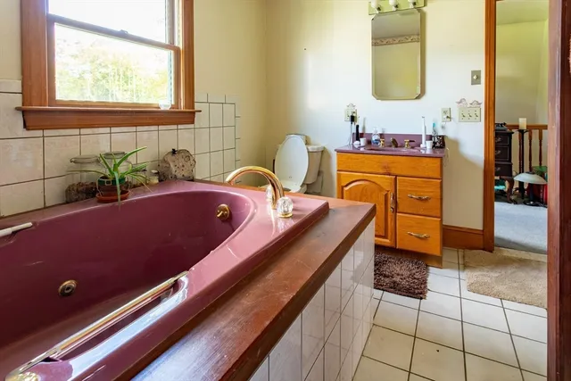 a bathroom with a tub sink and mirror