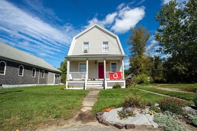 a view of a house with a yard potted plants and a table