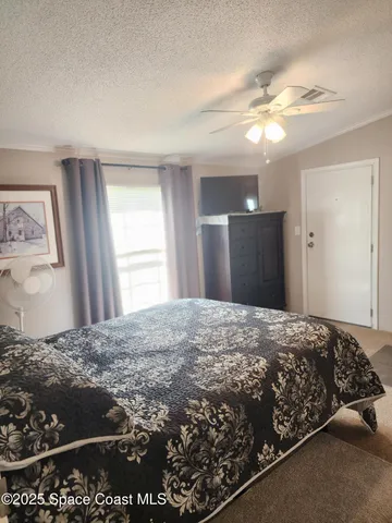 a bedroom with a large bed and a chandelier