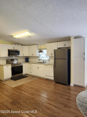 a kitchen with a refrigerator and a stove top oven