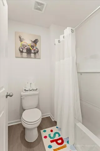 a white toilet sitting next to a shower curtain
