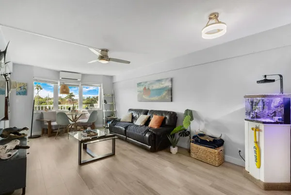 a living room with furniture flat screen tv and a large window