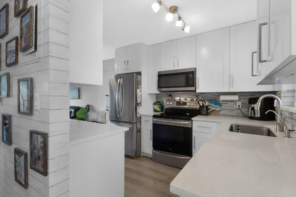 a kitchen with a refrigerator a stove top oven a sink and dishwasher