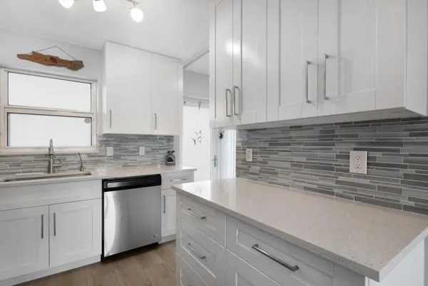 a kitchen with cabinets appliances and a sink