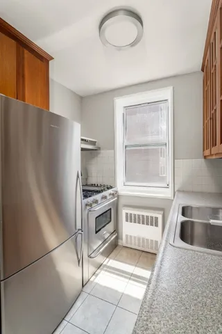 a kitchen with stainless steel appliances granite countertop a sink stove and refrigerator
