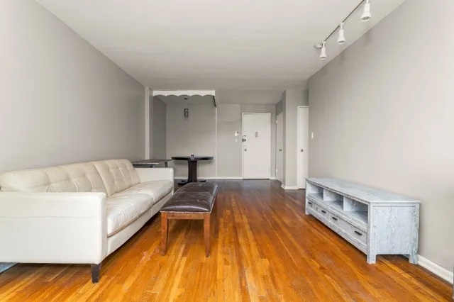 a living room with a bed furniture and a wooden floor