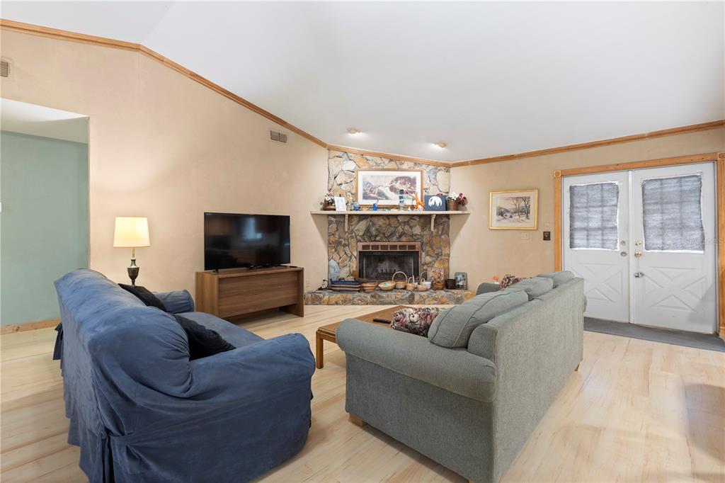 18321 McMullen Road Spring Hill, FL 34610 - Photo 17 of 56 a living room with furniture a flat screen tv and a fireplace