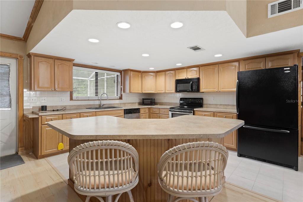 18321 McMullen Road Spring Hill, FL 34610 - Photo 21 of 56 a kitchen with stainless steel appliances granite countertop a refrigerator a sink a stove a microwave and island