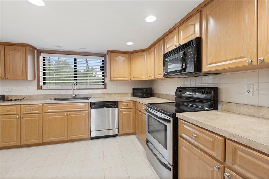 18321 McMullen Road Spring Hill, FL 34610 - Photo 23 of 56 a kitchen with stainless steel appliances granite countertop a stove sink and microwave
