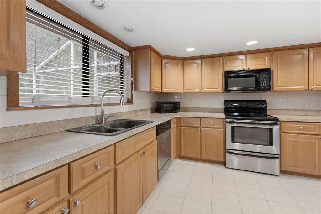 18321 McMullen Road Spring Hill, FL 34610 - Photo 24 of 56 a kitchen with granite countertop a sink and steel appliances