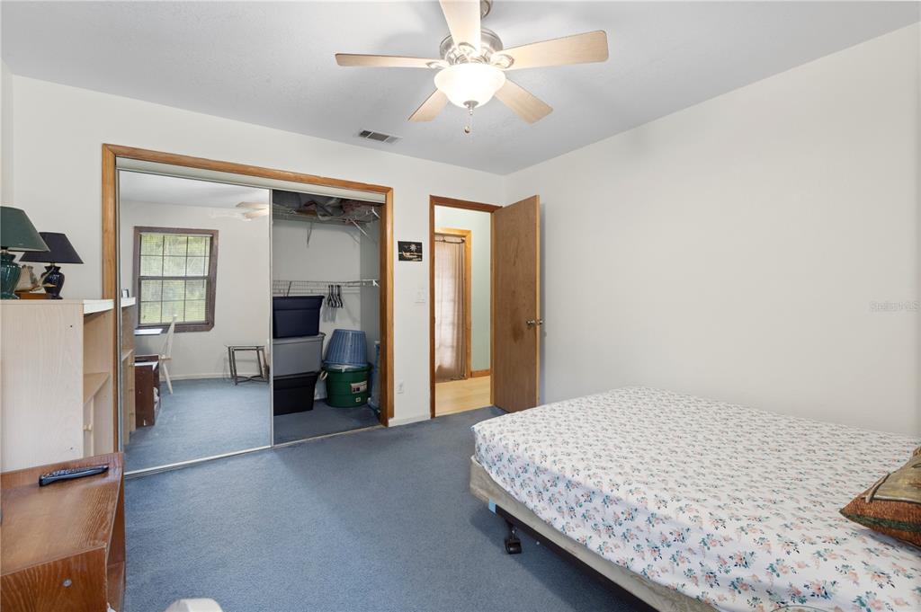 18321 McMullen Road Spring Hill, FL 34610 - Photo 36 of 56 a bedroom with a bed and a chandelier