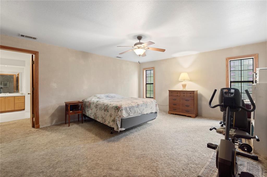 18321 McMullen Road Spring Hill, FL 34610 - Photo 38 of 56 a bedroom with a bed and a chandelier