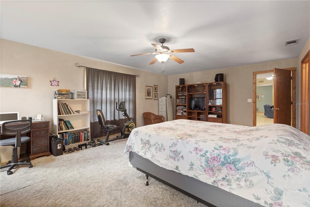 18321 McMullen Road Spring Hill, FL 34610 - Photo 39 of 56 a bedroom with a bed and dresser with chair