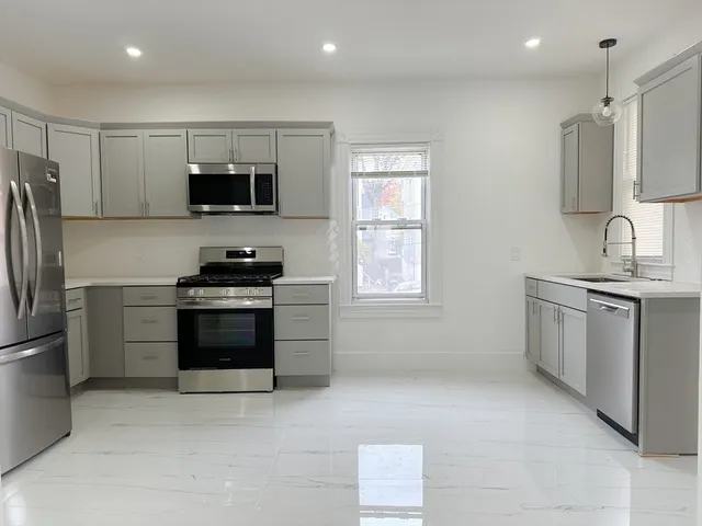 a kitchen with stainless steel appliances a refrigerator stove and microwave